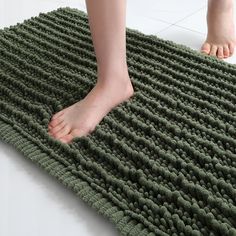 a person standing on top of a green rug