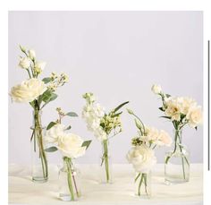 four vases with flowers in them on a table