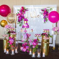 a table topped with lots of vases filled with flowers and candles next to balloons