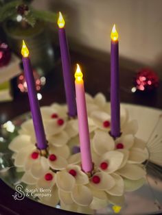 three candles are lit on a cake decorated with flowers