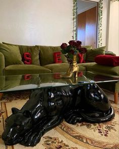 a glass coffee table with a black cat on it