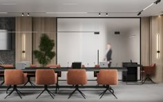 an empty conference room with orange chairs and a black table in front of a large screen