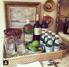 there are many bottles and glasses in the basket on the counter next to each other