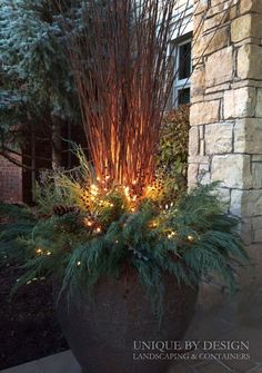 a planter with lights in it sitting next to a brick wall and stone building