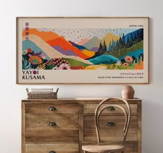 a wooden dresser sitting next to a painting on the wall