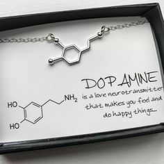 a necklace with the words dopamine on it and an image of a chemical model