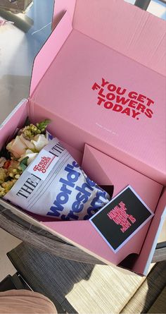 a pink box filled with food sitting on top of a table