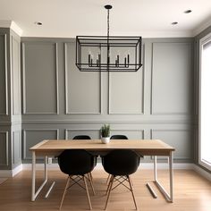 a dining room table with four chairs and a chandelier hanging from the ceiling