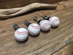 three baseball themed knobs are sitting on a wooden table