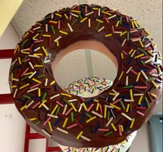 a giant donut with chocolate frosting and sprinkles is on display