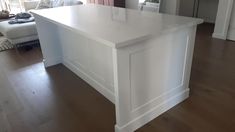 a white kitchen island sitting in the middle of a living room