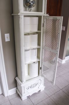 a white cabinet with many rolls of toilet paper in it