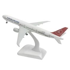 a white and red model airplane on a stand