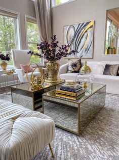 a living room filled with furniture and a painting on the wall above it's windows