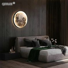 a large bed sitting in a bedroom next to a wall mounted clock with the moon on it