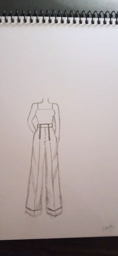 a drawing of a woman's pants and top on a notepad with a pen