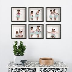 four framed pictures on the wall above a dresser with a plant and potted pine tree