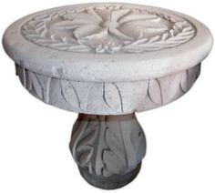 a white pedestal with a flower design on it