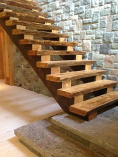 a set of stairs made out of wooden planks in front of a brick wall