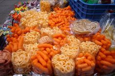 there are many different types of food on the display table, including carrots and macaroni shells