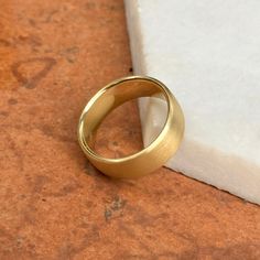 a gold wedding ring sitting on top of a piece of paper