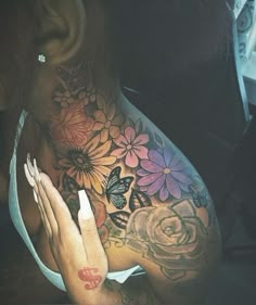 a woman's stomach with flowers and butterflies tattooed on her chest, showing the breast area