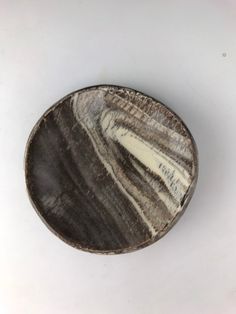 a wooden bowl sitting on top of a white table