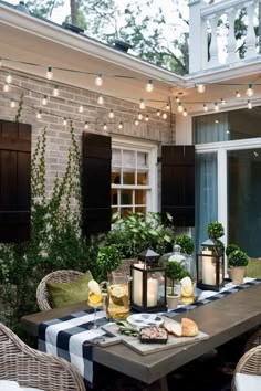 an outdoor dining table with candles and food on it