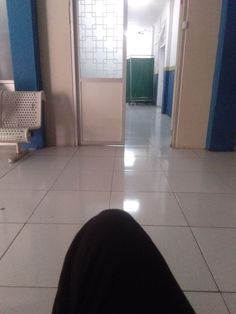 a person's feet on the floor in front of a hallway with blue and white walls