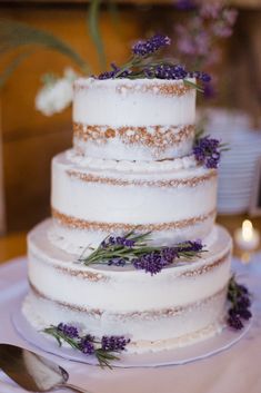 a three tiered cake with lavender flowers on top