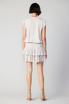 Done in a soft ecru shade, this short-sleeve mini dress ties up at the neckline and cinches in at the waist before falling to a thigh-skimming tiered hem with crisp, raw edges. The perfect one-and-done number for date night - not to mention one of Current Air's most popular dress. •V-neckline with tie •Relaxed fit •Ruffle trim •Pleated cap sleeves •Elasticized waist •Tiered pleated skirt •Raw edges Item number 1990061-1 100% Polyester Dry clean Imported Chic Knee-length Mini Dress With Gathered Waist, Day Out Mini Dress With Gathered Waist, Mini Dress With Gathered Waist For Day Out, Pleated Mini Dress For Day Out, Mini Dress With Pleated Waist For Day Out, Chic Tie Waist Tiered Skirt Dress, Chic Tiered Skirt Dress With Tie Waist, Chic Tie Waist Dress With Tiered Skirt, Chic Dresses With Tie Waist And Tiered Skirt