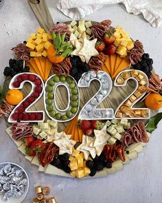 a platter filled with lots of different types of cheeses and fruits in the shape of numbers