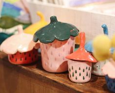 small ceramic cupcakes are lined up on a shelf