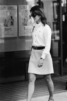 black and white photograph of woman walking on sidewalk