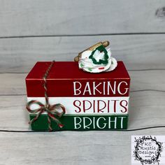 a red and green box sitting on top of a white wooden floor next to a sign that says baking spirits bright