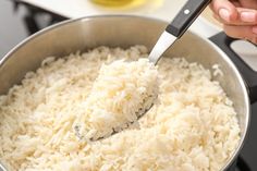 someone is stirring rice in a pot on the stove