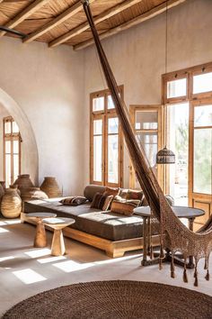 a room filled with lots of vases sitting on top of a wooden floor next to windows