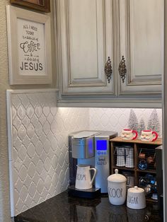 the coffee maker is on top of the counter in the kitchen, next to two mugs