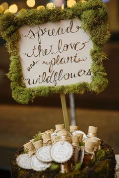 a sign that says spread the love and plants wildflowers on top of a cake