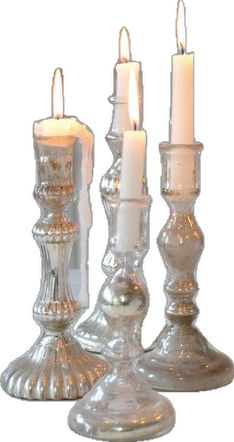 three glass candlesticks with one lit and the other turned on