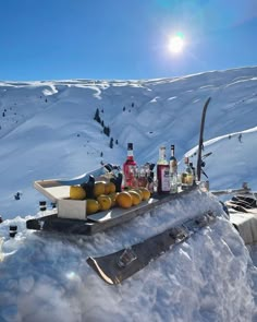 an assortment of drinks and liquors on a tray in the snow