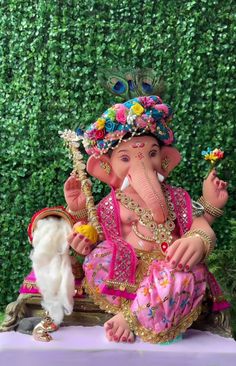 an elephant statue sitting on top of a table next to a white mouse and green wall