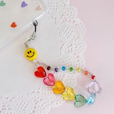 a keychain with hearts and smiley face charms attached to it's side