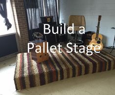 a room with a guitar and other musical equipment on the floor next to a brick wall