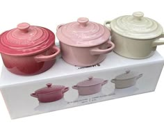 three different colored pots and pans sitting on top of a box