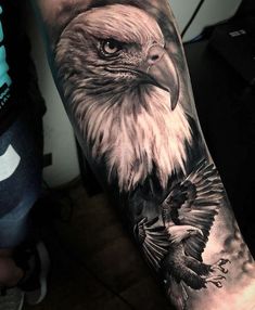 an eagle tattoo on the arm with a black and white photo behind it's head