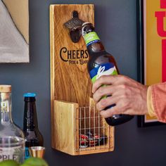 a person holding a beer bottle in front of a wooden rack