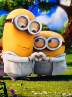 two minions from despicable me sitting in the grass