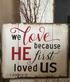 a wooden sign that says we love because he first loved us