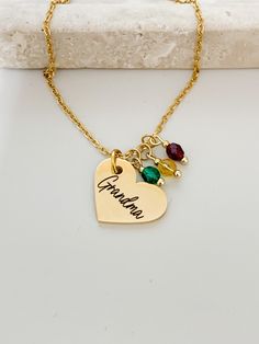 A beautiful heart shaped necklace with a personalized name of your choice, and the option to add your choice of birthstones.  Please leave the personalized name (only one name), and the birth month in the personalized box. Please choose your desired length and the number of birthstones from the drop down menu.  *Please note: The number of birth months that you note in the personalized box must equal the number that you chose from the drop down menu*  Details  *4mm birthstones *18k gold stainless Mother's Day Gold Birthstone Necklace With Name, Mother's Day Nameplate Birthstone Charm Necklace, Personalized Birthstone Name Necklace For Mother's Day, Grandma Necklace Birthstone, Flower-shaped Birthstone Necklaces For Mother's Day, Grandma Necklace, Necklace For Mom, Heart Shaped Necklace, Month Gifts